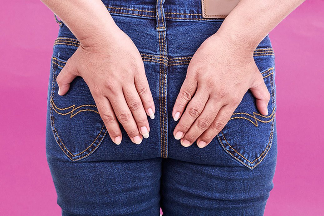 Women wearing jeans holding bum cheeks