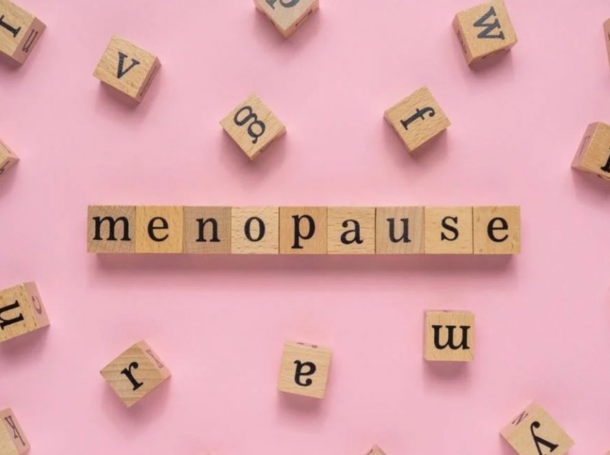Words 'menopause' in wooden blocks on a pink background
