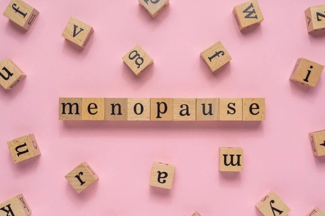 Words 'menopause' in wooden blocks on a pink background