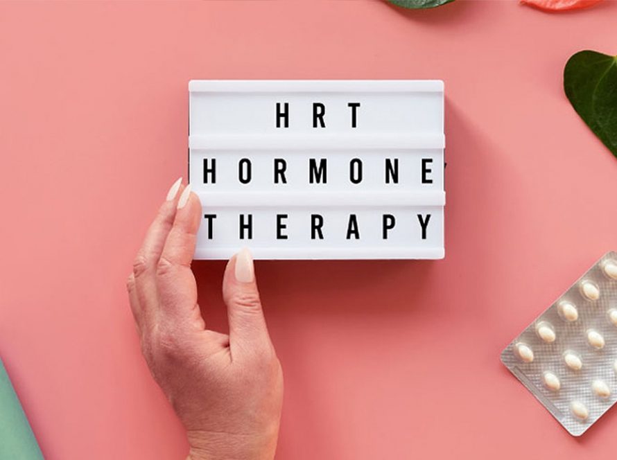 A hand holding a sign that says HRT Hormone Therapy