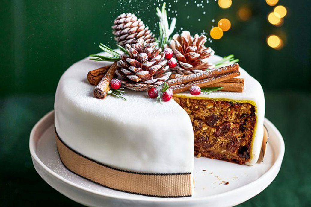 Christmas Cake with a slice cut out on a green festive background